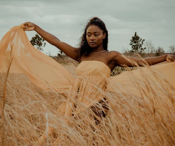 Person in a dynamic yoga flow pose outdoors with nature in the background.